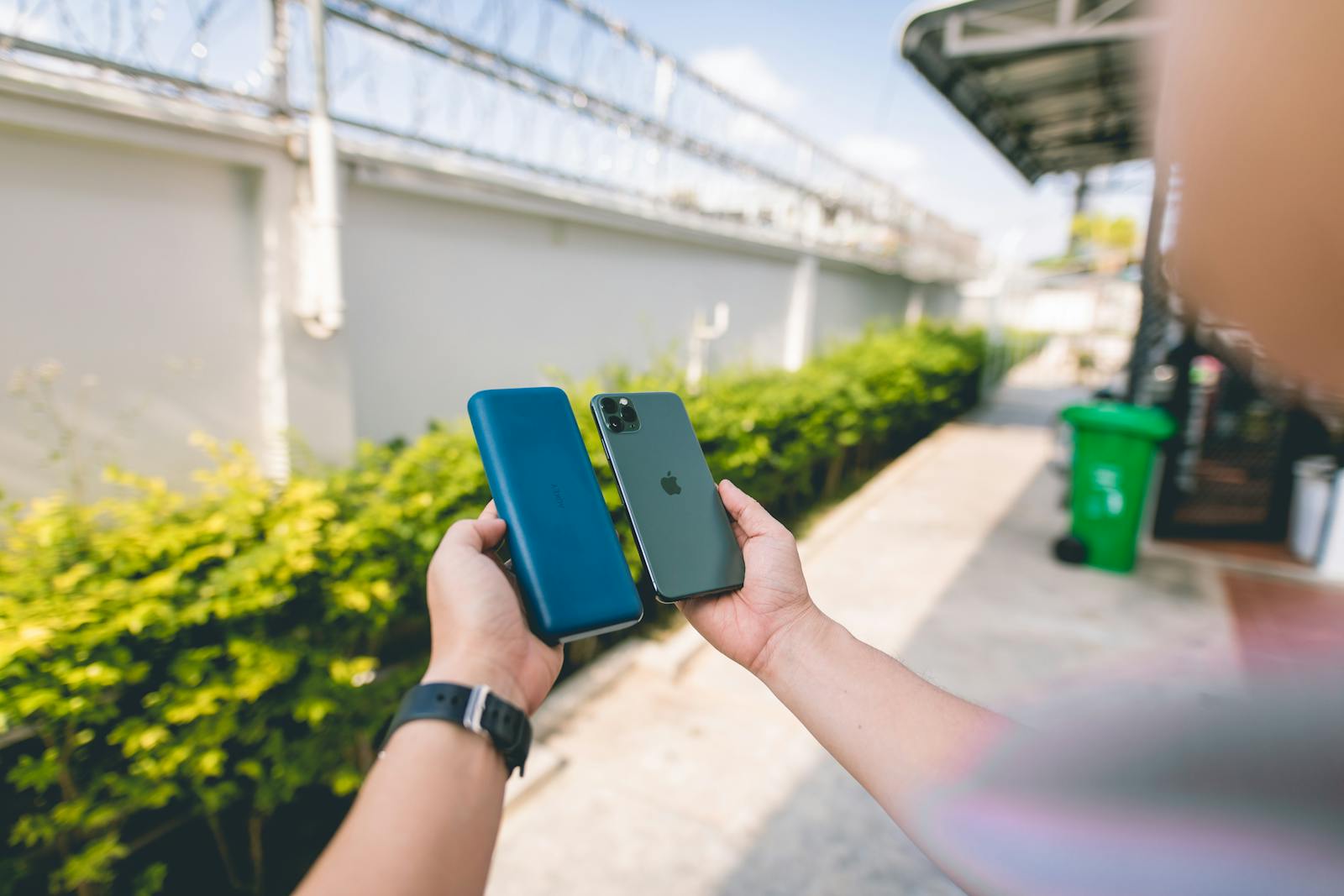 A Person Holding an iPhone 11 and a Power Bank